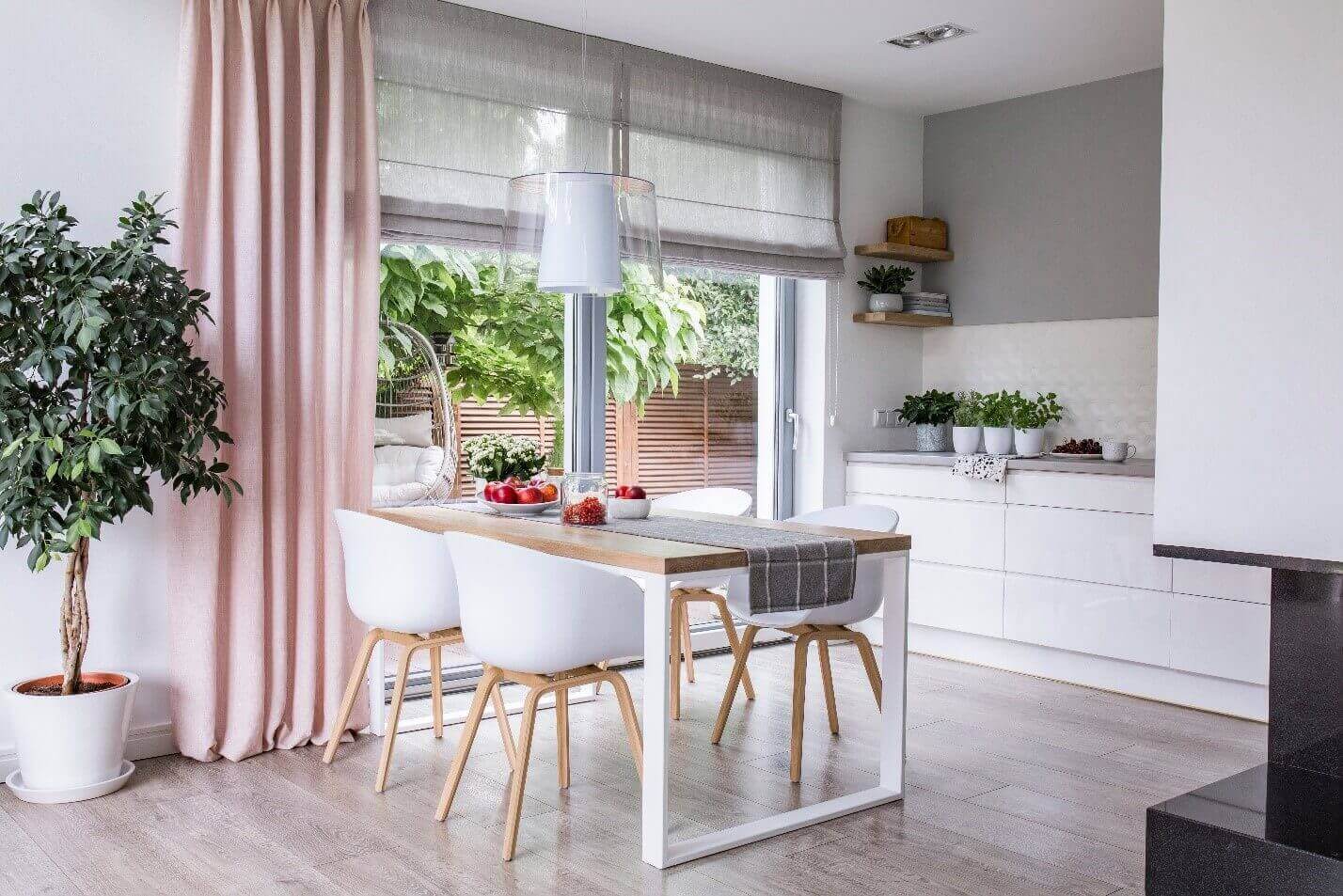 white kitchen with drapes and shades on sliding glass door 