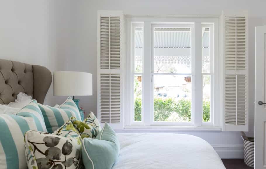 opened white shutters in a home bedroom
